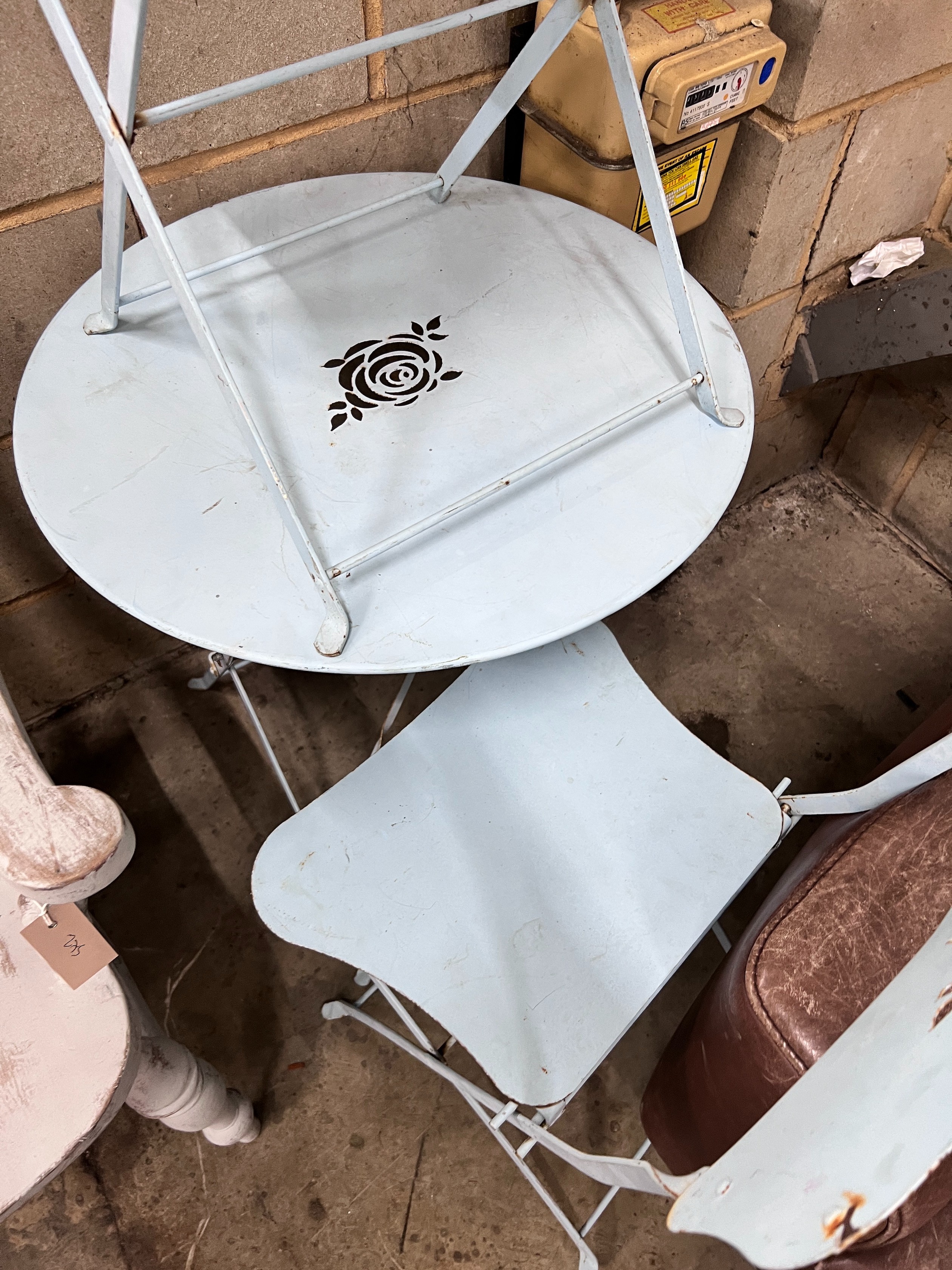 A blue painted wrought iron folding cafe table and pair of matching chairs, diameter 60cm, height 69cm *Please note the sale commences at 9am.